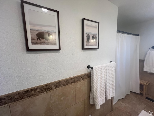240 S 100 E, Logan, UT 84321 - full bathroom with tile patterned flooring, a shower with shower curtain, and tile walls