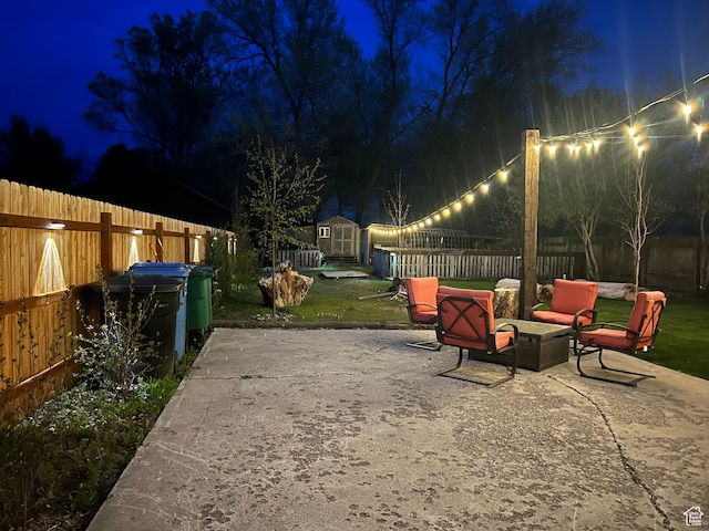 240 S 100 E, Logan, UT 84321 - patio at twilight featuring a fenced backyard, an outbuilding, and a storage shed