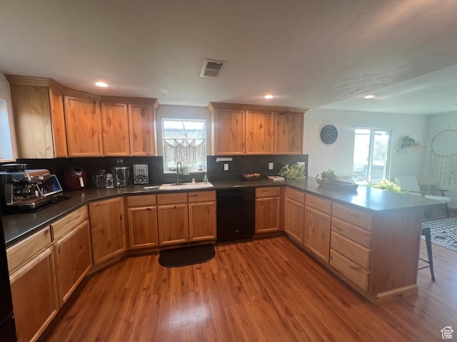 240 S 100 E, Logan, UT 84321 - kitchen with a sink, dishwasher, a peninsula, wood finished floors, and visible vents