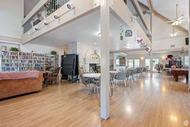 54 Cottonwood Ln, Hurricane, UT 84737 - living room with wood finished floors, ceiling fan, a fireplace, and a towering ceiling