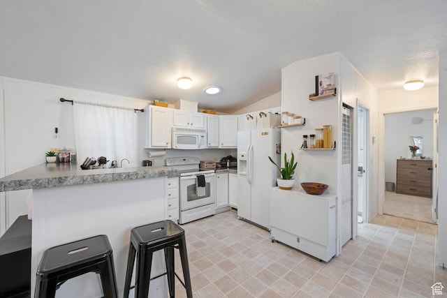 54 Cottonwood Ln, Hurricane, UT 84737 - kitchen featuring open shelves, a breakfast bar area, a peninsula, white appliances, and lofted ceiling