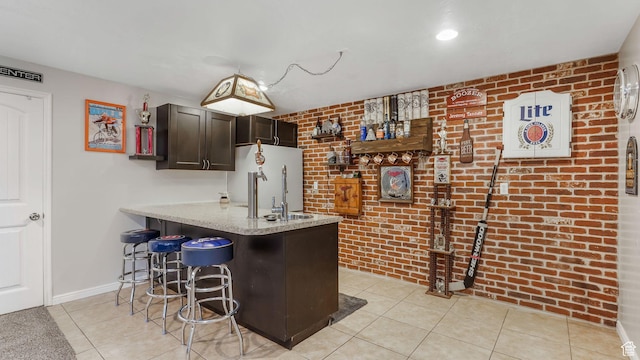 5394 W Shaggy Peak Dr, Riverton, UT 84096 - bar with light tile patterned floors, fridge, baseboards, brick wall, and indoor wet bar