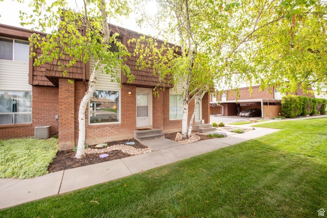 3937 S Lamplighter Way Unit 23, Riverdale, UT 84405 - view of front of house with brick siding, entry steps, a front lawn, and mansard roof
