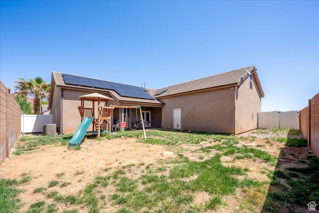 388 E 1060 S, Ivins, UT 84738 - rear view of house featuring roof mounted solar panels, a playground, stucco siding, and a fenced backyard