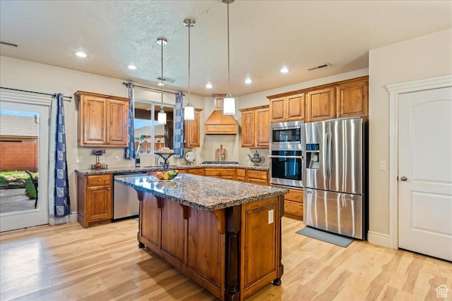 388 E 1060 S, Ivins, UT 84738 - kitchen featuring appliances with stainless steel finishes, visible vents, premium range hood, and brown cabinetry