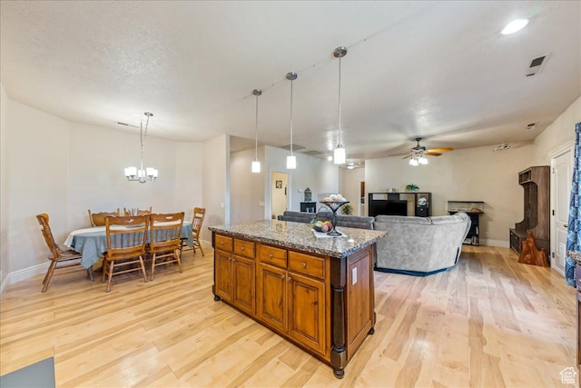 388 E 1060 S, Ivins, UT 84738 - kitchen with brown cabinets, a kitchen island, baseboards, light wood-type flooring, and ceiling fan with notable chandelier