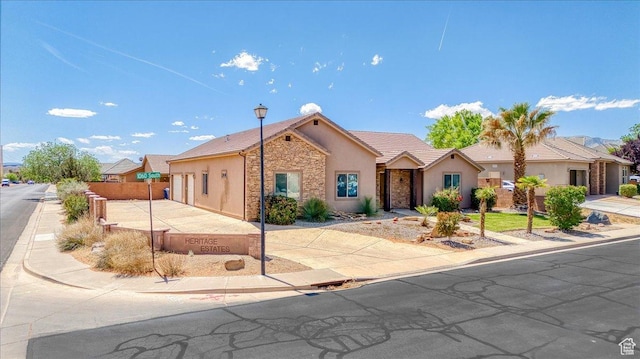388 E 1060 S, Ivins, UT 84738 - ranch-style home featuring fence, concrete driveway, stone siding, a tiled roof, and stucco siding