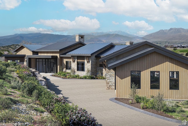2177 E Notch Cir Unit 354, Heber City, UT 84032 - view of front of home with a standing seam roof, a mountain view, a chimney, metal roof, and stone siding