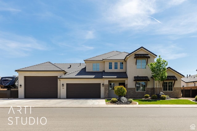 309 W Blue Quartz Dr, Washington, UT 84780 - view of front facade featuring stucco siding, brick siding, concrete driveway, an attached garage, and fence