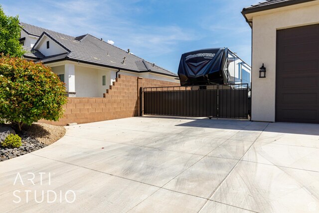 309 W Blue Quartz Dr, Washington, UT 84780 - view of patio featuring driveway, fence, a gate, and a garage
