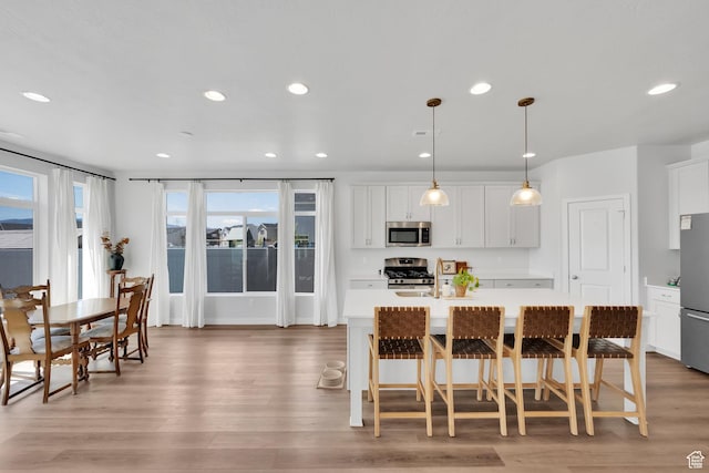 315 W 910 S, American Fork, UT 84003 - kitchen featuring appliances with stainless steel finishes, light wood-style floors, an island with sink, and light countertops