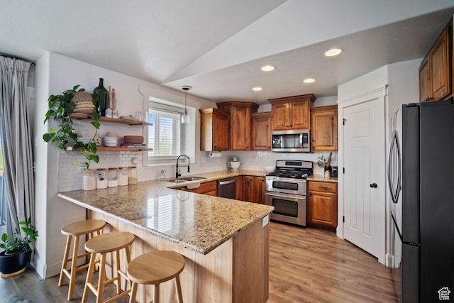9457 N 4800 W, Elwood, UT 84337 - kitchen featuring brown cabinets, stainless steel appliances, a peninsula, and a sink