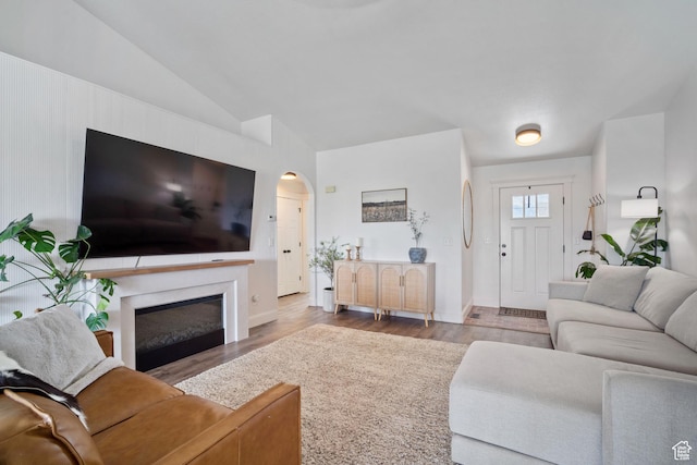 9457 N 4800 W, Elwood, UT 84337 - living area featuring wood finished floors, arched walkways, a fireplace, baseboards, and lofted ceiling