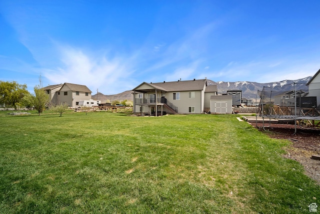 9457 N 4800 W, Elwood, UT 84337 - view of yard with a trampoline, stairway, an outbuilding, a storage shed, and a mountain view