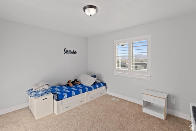 unfurnished bedroom featuring baseboards, visible vents, and carpet