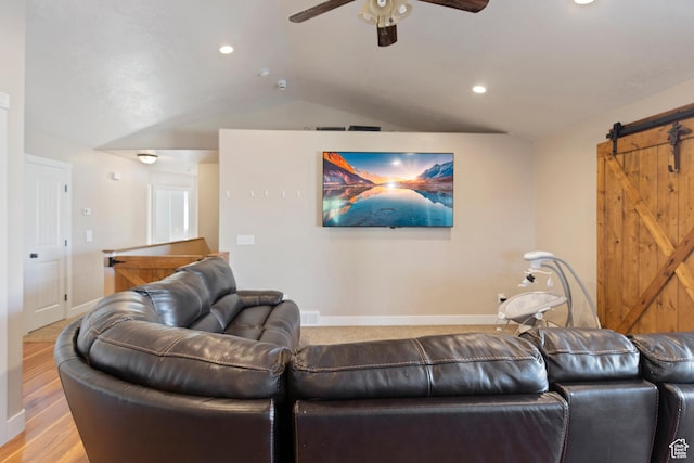 living area with a ceiling fan, lofted ceiling, a barn door, and baseboards