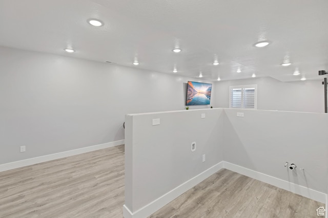 below grade area with recessed lighting, light wood finished floors, and baseboards