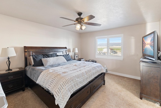 bedroom with ceiling fan, light colored carpet, and baseboards