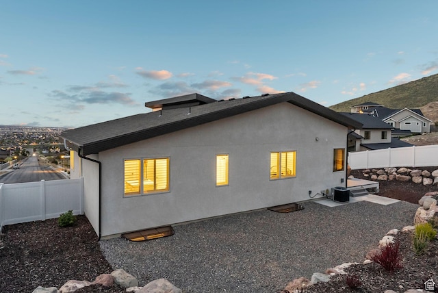 6593 W Bonnie Jean Ln Unit 13, Herriman, UT 84096 - back of house at dusk with central air condition unit, stucco siding, and a fenced backyard