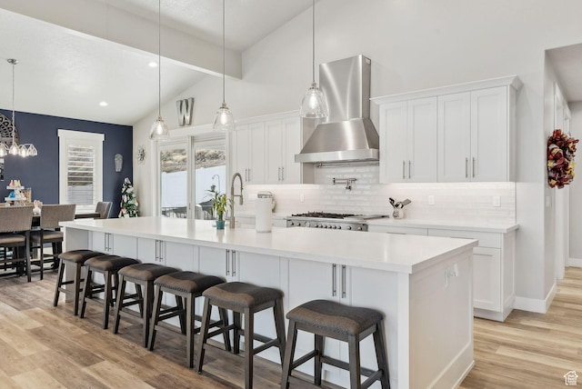 6593 W Bonnie Jean Ln Unit 13, Herriman, UT 84096 - kitchen featuring light wood-style flooring, backsplash, white cabinetry, wall chimney exhaust hood, and lofted ceiling
