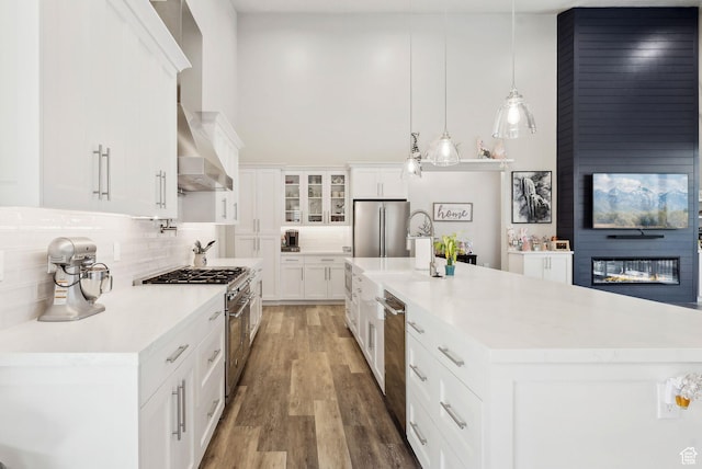 6593 W Bonnie Jean Ln Unit 13, Herriman, UT 84096 - kitchen featuring tasteful backsplash, appliances with stainless steel finishes, light countertops, wall chimney range hood, and white cabinets
