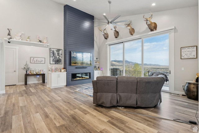 6593 W Bonnie Jean Ln Unit 13, Herriman, UT 84096 - living area with a fireplace, ceiling fan, light wood-type flooring, and a high ceiling