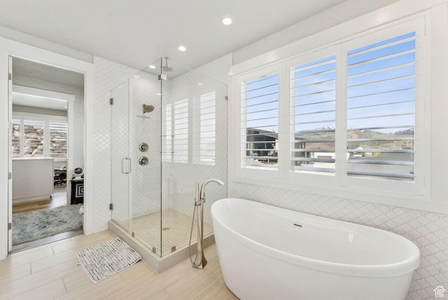 6593 W Bonnie Jean Ln Unit 13, Herriman, UT 84096 - bathroom featuring a freestanding tub, wood finished floors, a shower stall, and recessed lighting