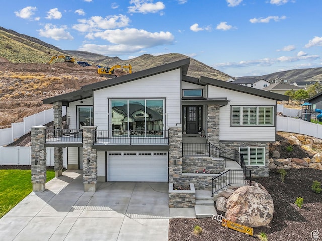 6593 W Bonnie Jean Ln Unit 13, Herriman, UT 84096 - contemporary house with concrete driveway, stone siding, a mountain view, fence, and a garage