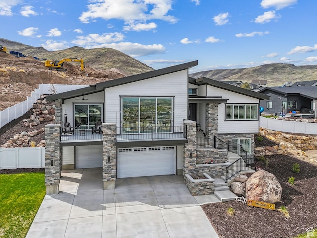 6593 W Bonnie Jean Ln Unit 13, Herriman, UT 84096 - view of front of property with stairway, a garage, a mountain view, driveway, and fence
