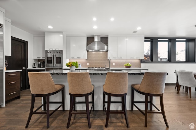 88 King Rd, Park City, UT 84060 - kitchen with oven, an island with sink, modern cabinets, wall chimney exhaust hood, and a sink