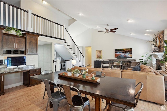 1380 Angel Crest Way, Kaysville, UT 84037 - dining room with a fireplace, high vaulted ceiling, light wood-type flooring, a ceiling fan, and stairs