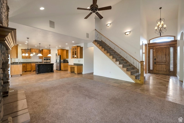 10252 S 3570 W, South Jordan, UT 84095 - unfurnished living room featuring visible vents, high vaulted ceiling, ceiling fan with notable chandelier, and stairs