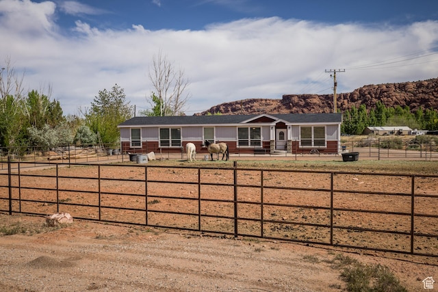 4147 S Spanish Valley Dr, Moab, UT 84532 - ranch-style house featuring a mountain view, board and batten siding, fence, and a shingled roof