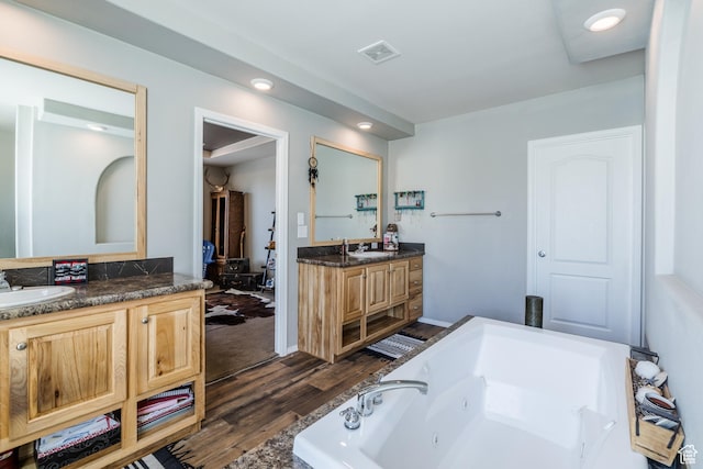 4147 S Spanish Valley Dr, Moab, UT 84532 - bathroom featuring a sink, a jetted tub, visible vents, and wood finished floors