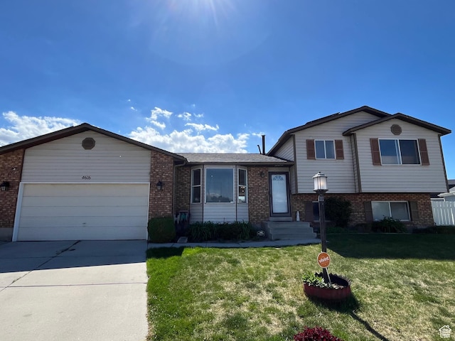 4616 S 3720 W, West Valley City, UT 84120 - tri-level home featuring brick siding, a garage, a front lawn, and driveway