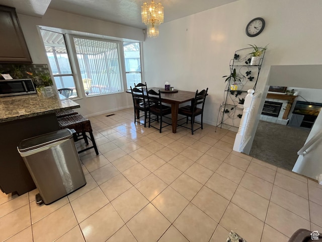 4616 S 3720 W, West Valley City, UT 84120 - dining area with a tiled fireplace, light tile patterned floors, baseboards, and a chandelier