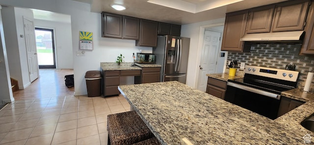 4616 S 3720 W, West Valley City, UT 84120 - kitchen featuring light stone countertops, stainless steel appliances, baseboards, decorative backsplash, and under cabinet range hood