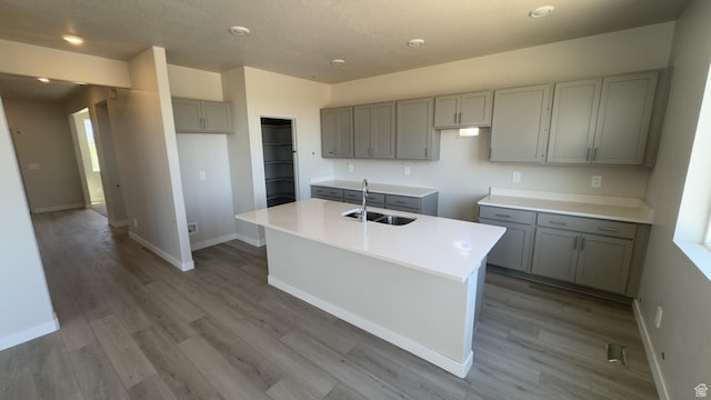 3467 S 3100 W Unit 176, West Haven, UT 84401 - kitchen with a sink, gray cabinets, a kitchen island with sink, wood finished floors, and baseboards