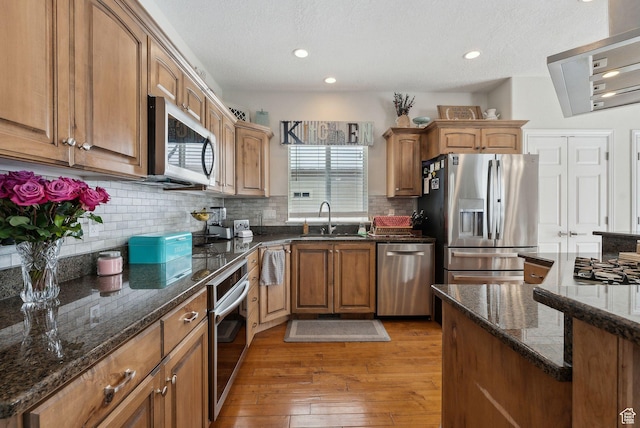 53 W 300 S, Midway, UT 84049 - kitchen featuring dark stone countertops, a sink, stainless steel appliances, light wood finished floors, and backsplash