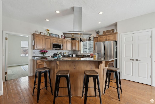 53 W 300 S, Midway, UT 84049 - kitchen with island range hood, a breakfast bar area, stainless steel appliances, light wood-style floors, and a sink