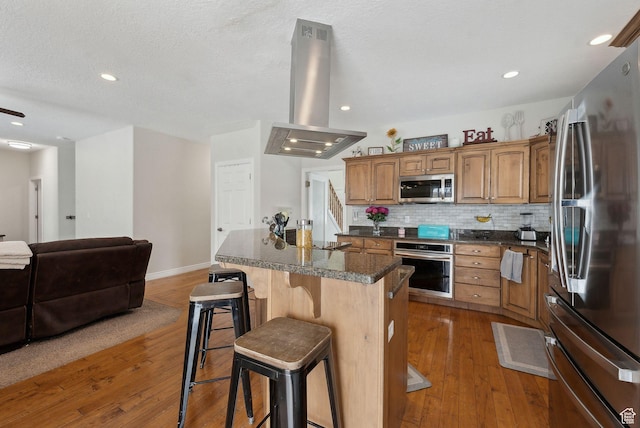 53 W 300 S, Midway, UT 84049 - kitchen with wood-type flooring, island exhaust hood, a center island, a breakfast bar, and appliances with stainless steel finishes