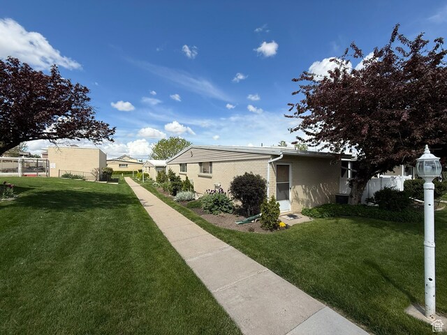 379 W 400 N Unit 7, Bountiful, UT 84010 - view of home's exterior with brick siding, fence, and a lawn