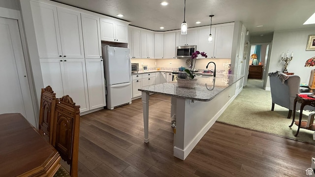 379 W 400 N Unit 7, Bountiful, UT 84010 - kitchen with recessed lighting, stainless steel microwave, freestanding refrigerator, white cabinetry, and a peninsula