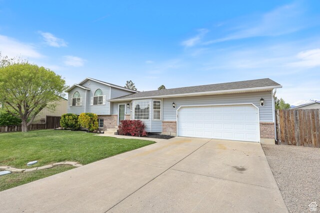 2627 E 1680 S, Spanish Fork, UT 84660 - tri-level home featuring brick siding, fence, a garage, a front lawn, and concrete driveway