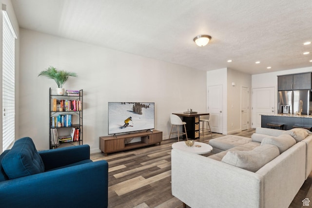living room with recessed lighting, baseboards, and wood finished floors