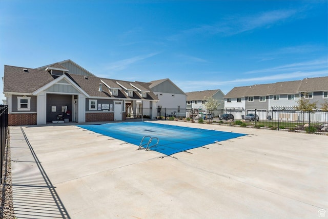 pool with fence, a patio, and a residential view