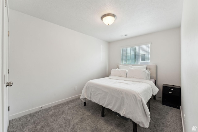 bedroom with carpet floors, baseboards, a textured ceiling, and visible vents