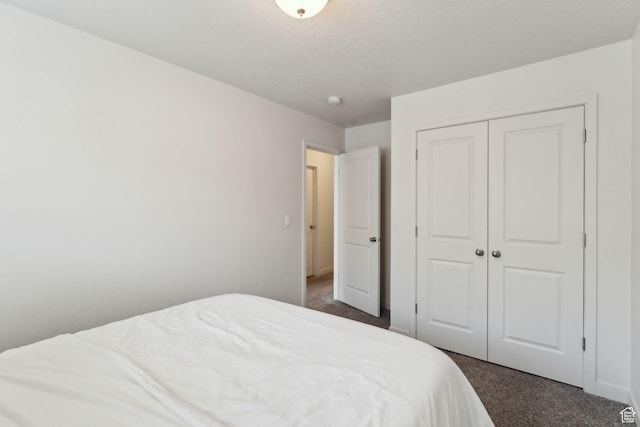 bedroom with a closet and dark carpet