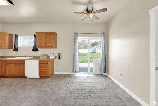kitchen with light countertops, white dishwasher, a sink, baseboards, and a ceiling fan