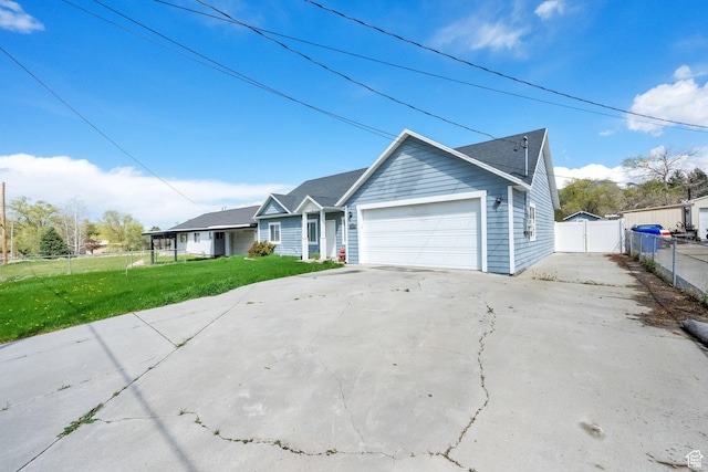 ranch-style home with driveway, fence, a front lawn, and an attached garage